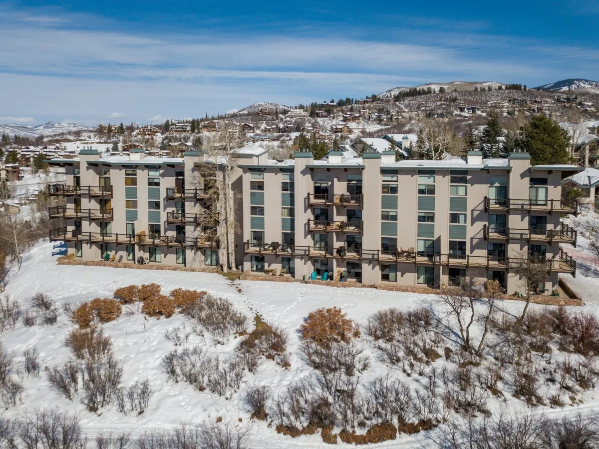 This view highlights the property’s exterior structure, featuring inviting balconies and a snowy landscape. The clean building lines and undisturbed snow on the ground evoke a sense of orderliness and well-kept surroundings, aligning with the promise of an allergy-aware sanctuary.